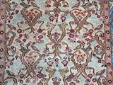 an antique persian rug with a floral design on a blue ground