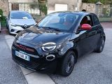une petite voiture noire garée sur le bord de la route