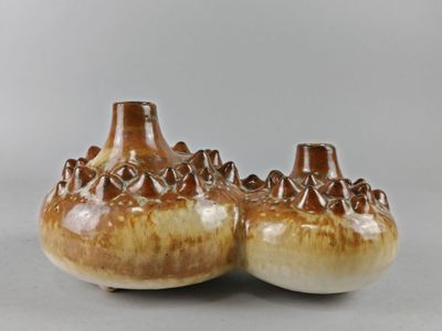 une paire de vases marron et blancs posés sur une table