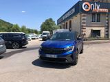 the blue car is parked in front of a building on the side of the road