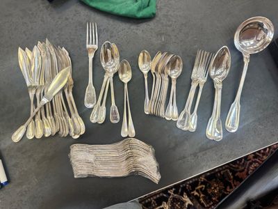 a lot of silver spoons and forks on a table
