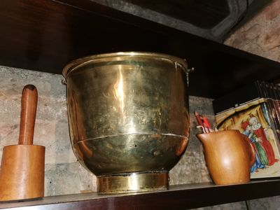 a large brass pot on a shelf next to other items