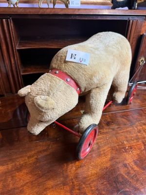 un ours en peluche assis sur une petite voiture