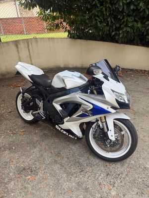 a white and blue motorcycle parked in a parking lot