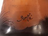 a brown vase with black writing on the side of it