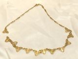 a close up of a gold necklace on a white cloth