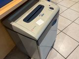 a paper shredder sitting on the floor next to a pair of shoes