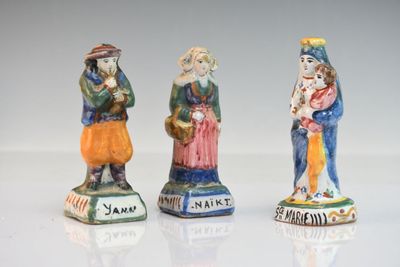 trois figurines en céramique représentant trois personnes debout les unes à côté des autres sur une surface blanche