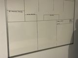 un homme debout devant un tableau blanc sur lequel figure un calendrier