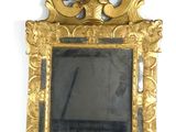 a gold frame with a mirror in it on the wall