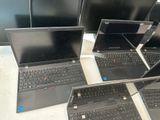 several laptops are lined up on a table in a row