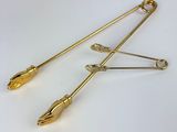 two gold - plated safety pins with an arrow on each end