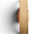 a close up of a watch on a white surface