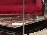 une photo d'un salon avec un canapé rouge et une table