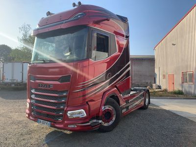 un semi-remorque rouge garé devant un immeuble