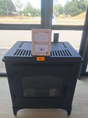 a small black stove sitting in front of a window