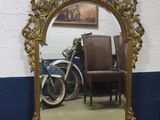 a mirror that is sitting on the floor next to a chair