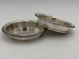 a pair of silver plated bowls on a white surface