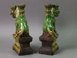 two green vases sitting on top of each other on top of a table