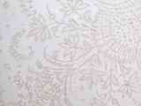 a close up of a bed with a white comforter and a pillow