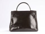 a black handbag sitting on top of a white surface