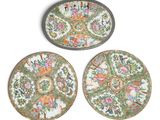 three plates with floral designs on them sitting on a white surface