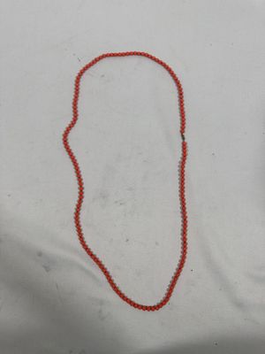 un collier de perles rouges orné d'une petite perle rouge