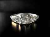a close up of a diamond ring on a black surface