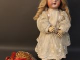 a doll that is standing next to a hat