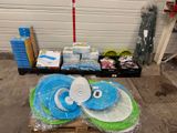 une pile d'assiettes bleues et vertes posée sur une palette devant la porte d'un garage