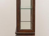 an old wooden display cabinet with glass shelves on top of it