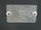 a metal plate with two white knobs on it