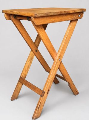 an old wooden folding table with two crossed legs on a white background