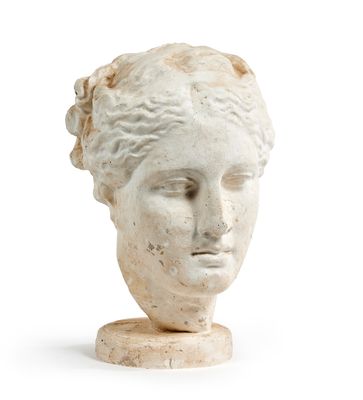 tête de femme en marbre posée sur un socle, sur fond blanc