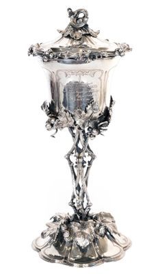 a silver cup with a lid on a stand
