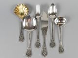 five spoons, two forks, and a spoon with a shell on it