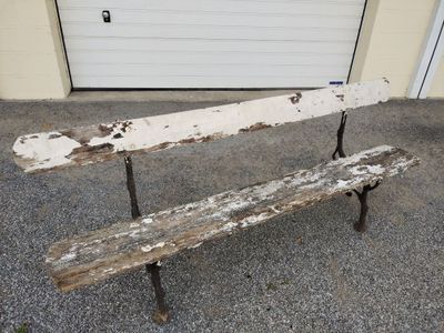 un banc en bois posé devant un garage
