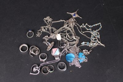 un tas de bijoux en argent posés sur une surface noire