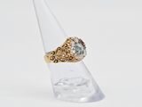 a close up of a gold ring with a blue topaz stone