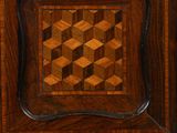 a close up of a clock on a wooden table with a mirror