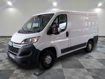 la camionnette blanche est garée sur un sol en damier dans le garage