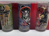 three shot glasses with different designs on them sitting on a table