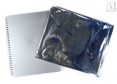 un ordinateur portable et un cahier posés sur une surface blanche