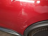 a close up of a red car that has been dented