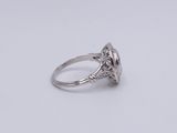 a close up of a diamond ring on a white surface