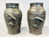two vases sitting side by side on a white surface