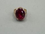 a close up of a ring with a red stone in it