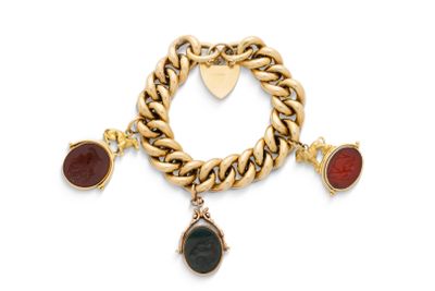 un gros plan sur un bracelet en or orné de pierres rouges et noires