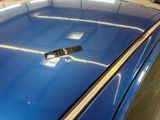 a blue car that has a sticker on the hood of it