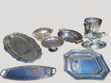 de nombreuses assiettes et plateaux en argent posés sur la table